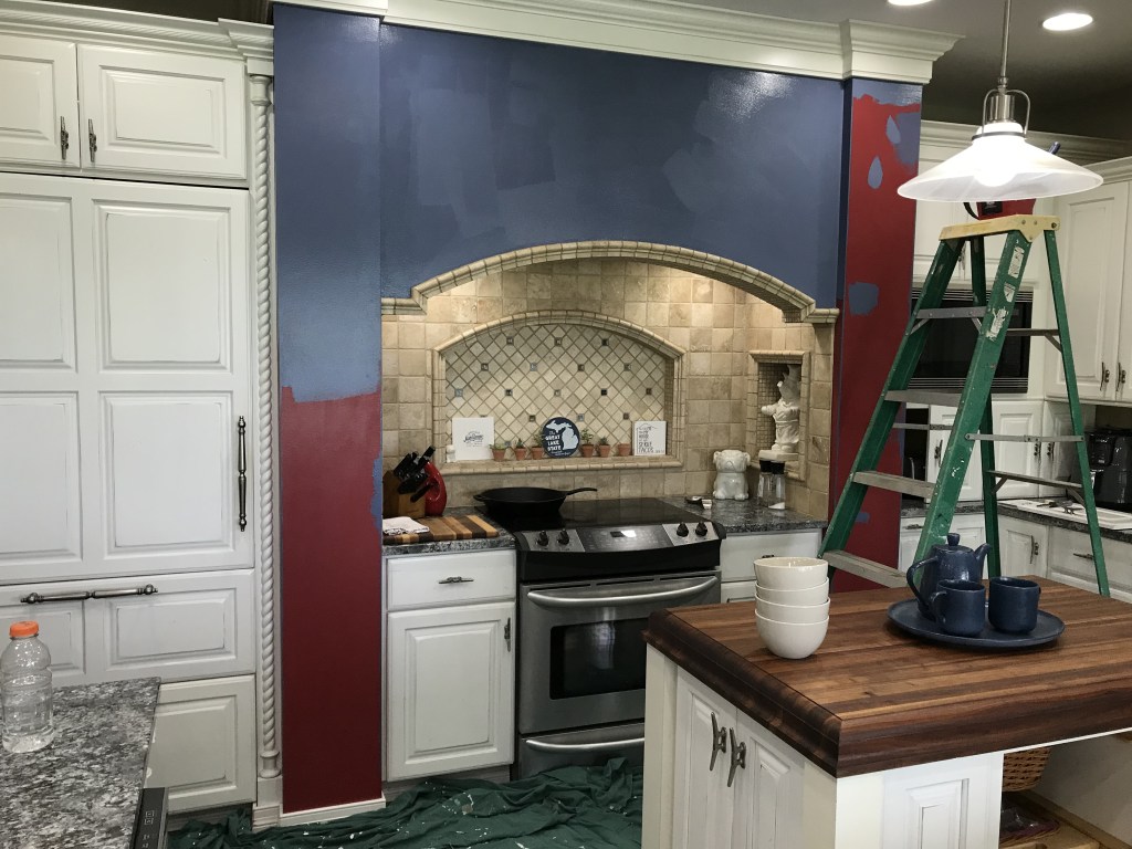 Kitchen wall around the stove in the process of being painted blue. 