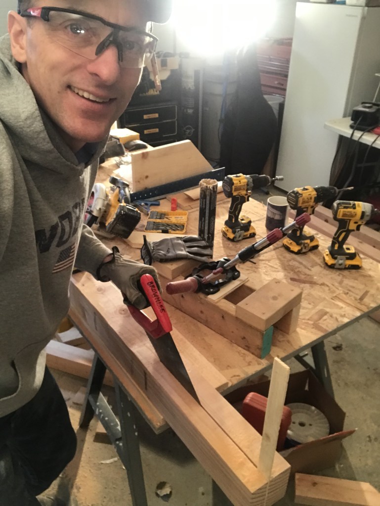 William cutting a post with a hand saw. 